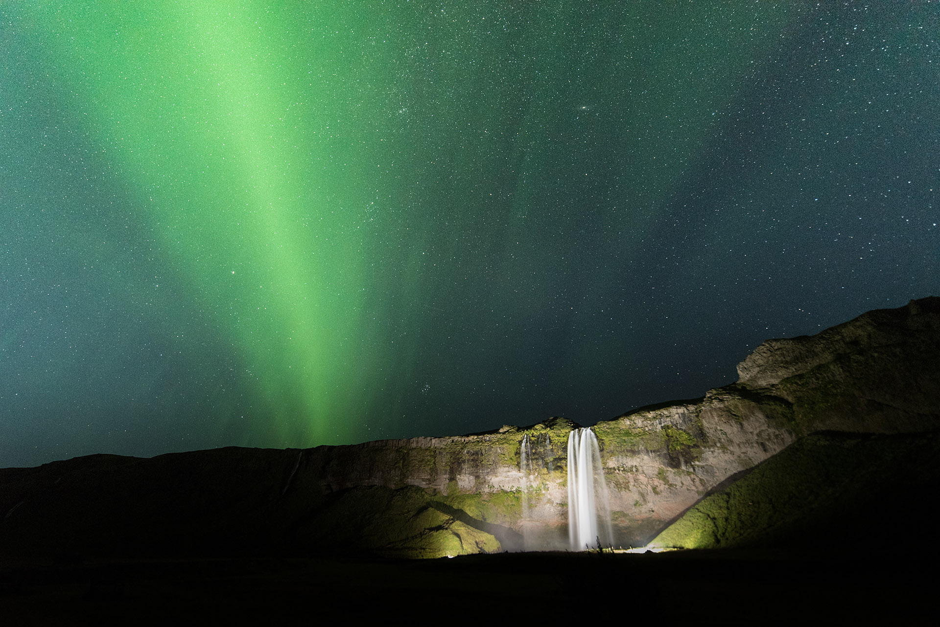 The Northern Lights dance above Seljelandsfoss waterfall