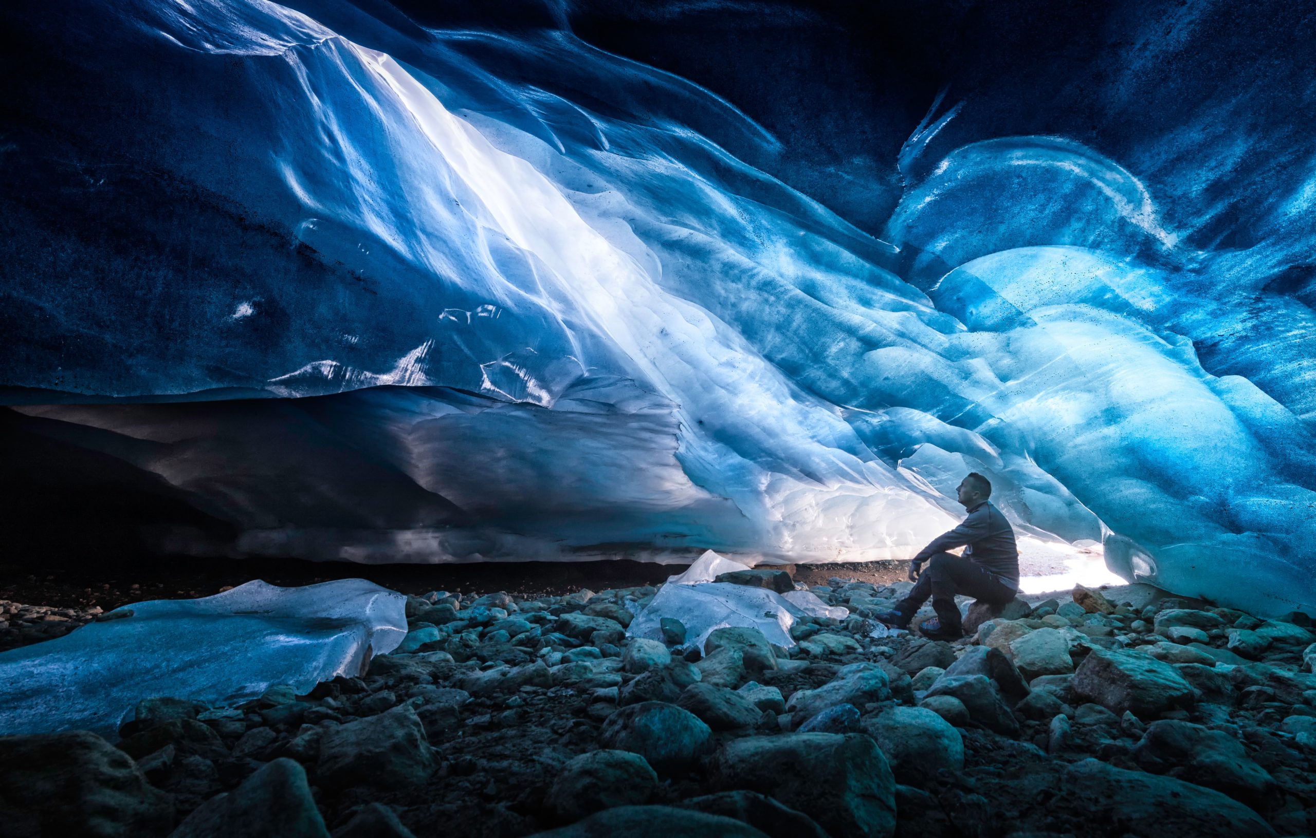 A man sits inside an ice cave in Iceland
