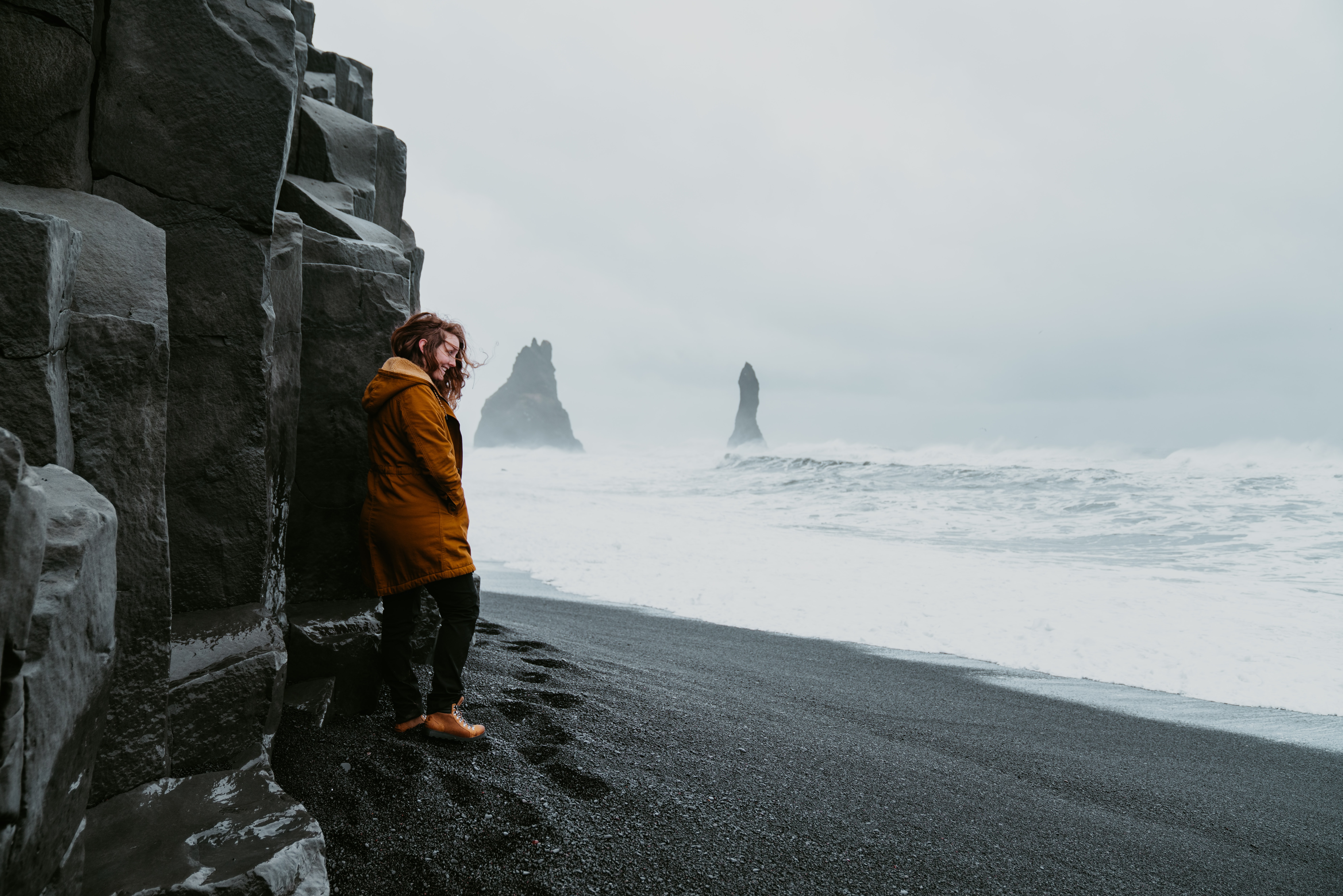 A young woman visiting Reynisfjara beach during the winter