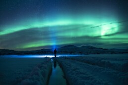 A man watching the Northern Lights in Iceland