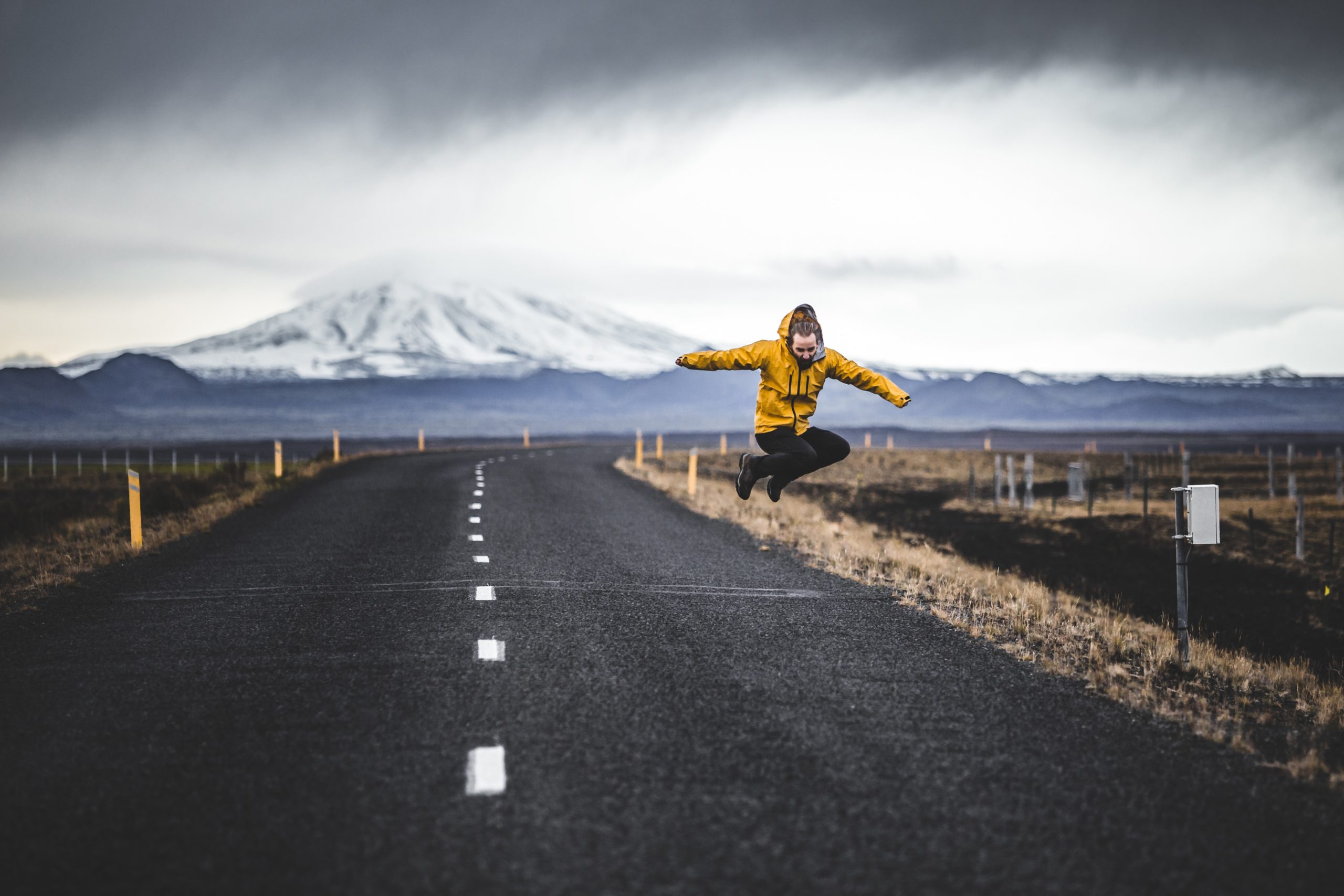 A man jumps on a road in Iceland