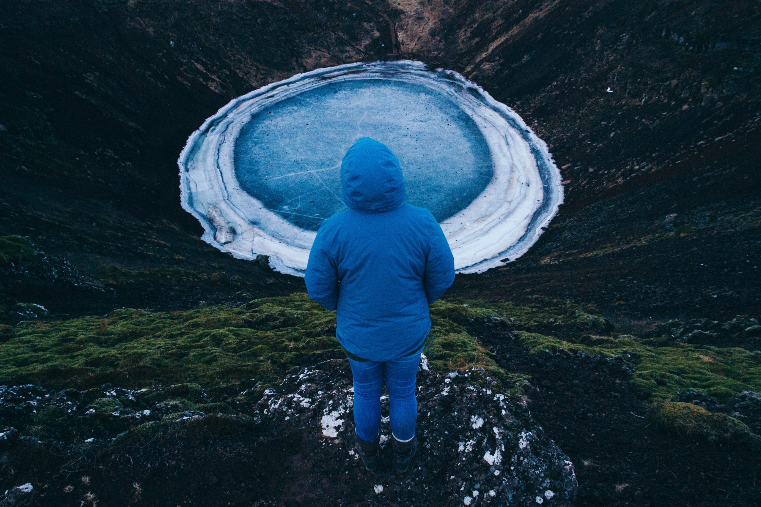 A woman looks kerið crater and its frozen pool