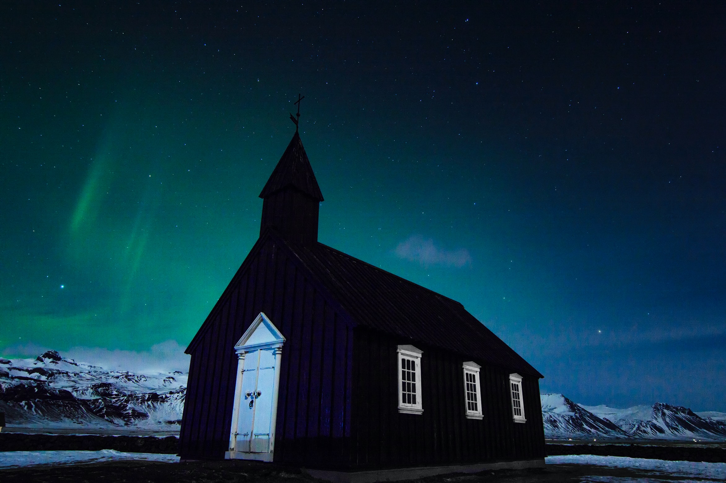Northern Lights over a black church in Iceland
