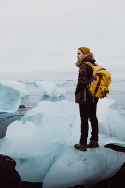 A man stands on an iceberg at J&ouml;kuls&aacute;rl&oacute;n