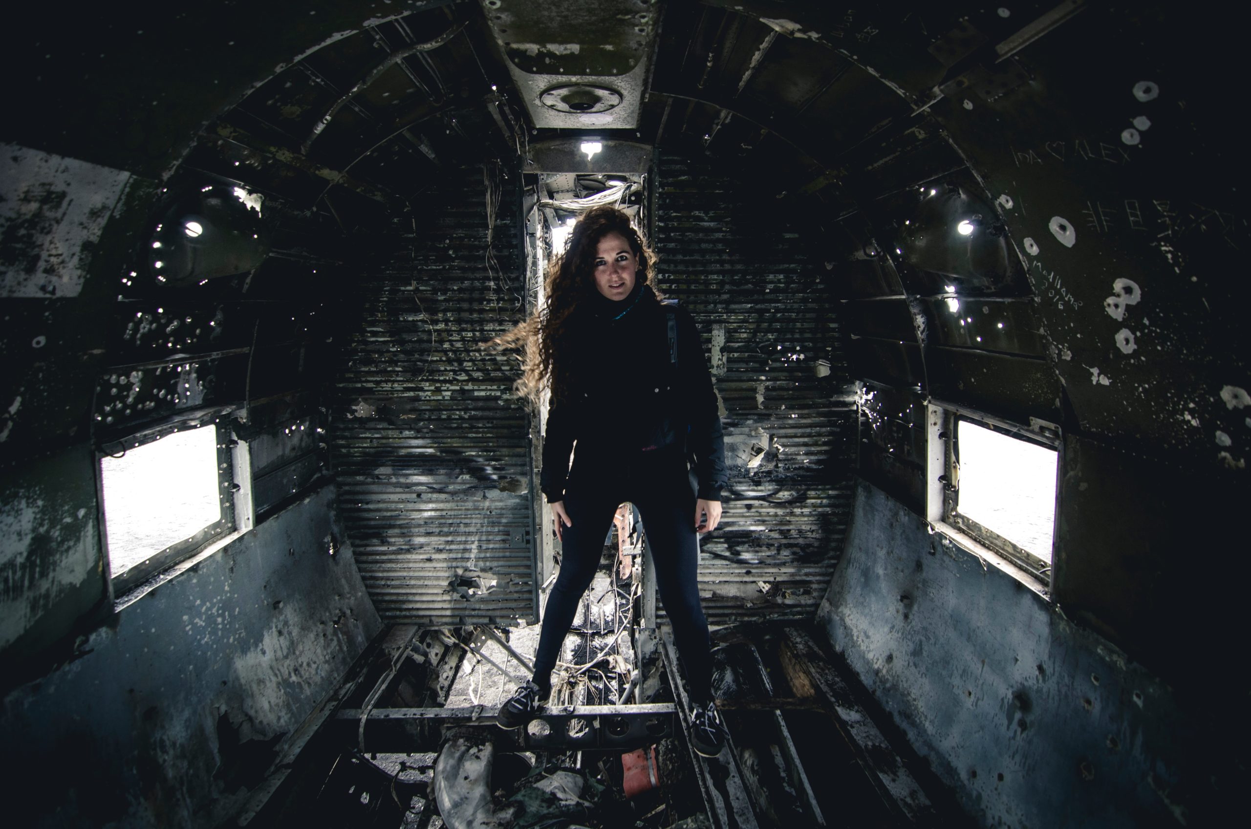 A woman stands inside the wreckage of the Douglas Dakota in Iceland