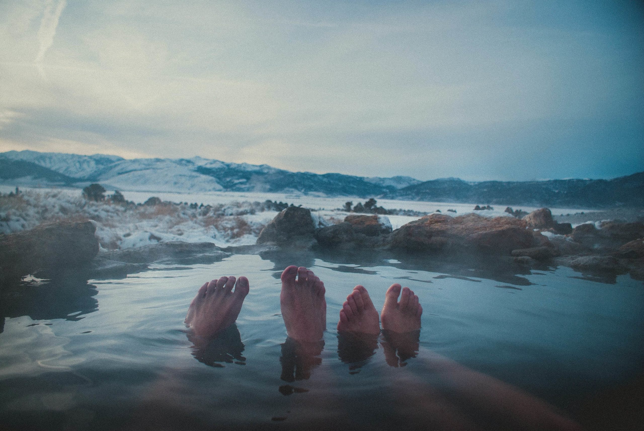 Two pairs of feet in a natural hot spring
