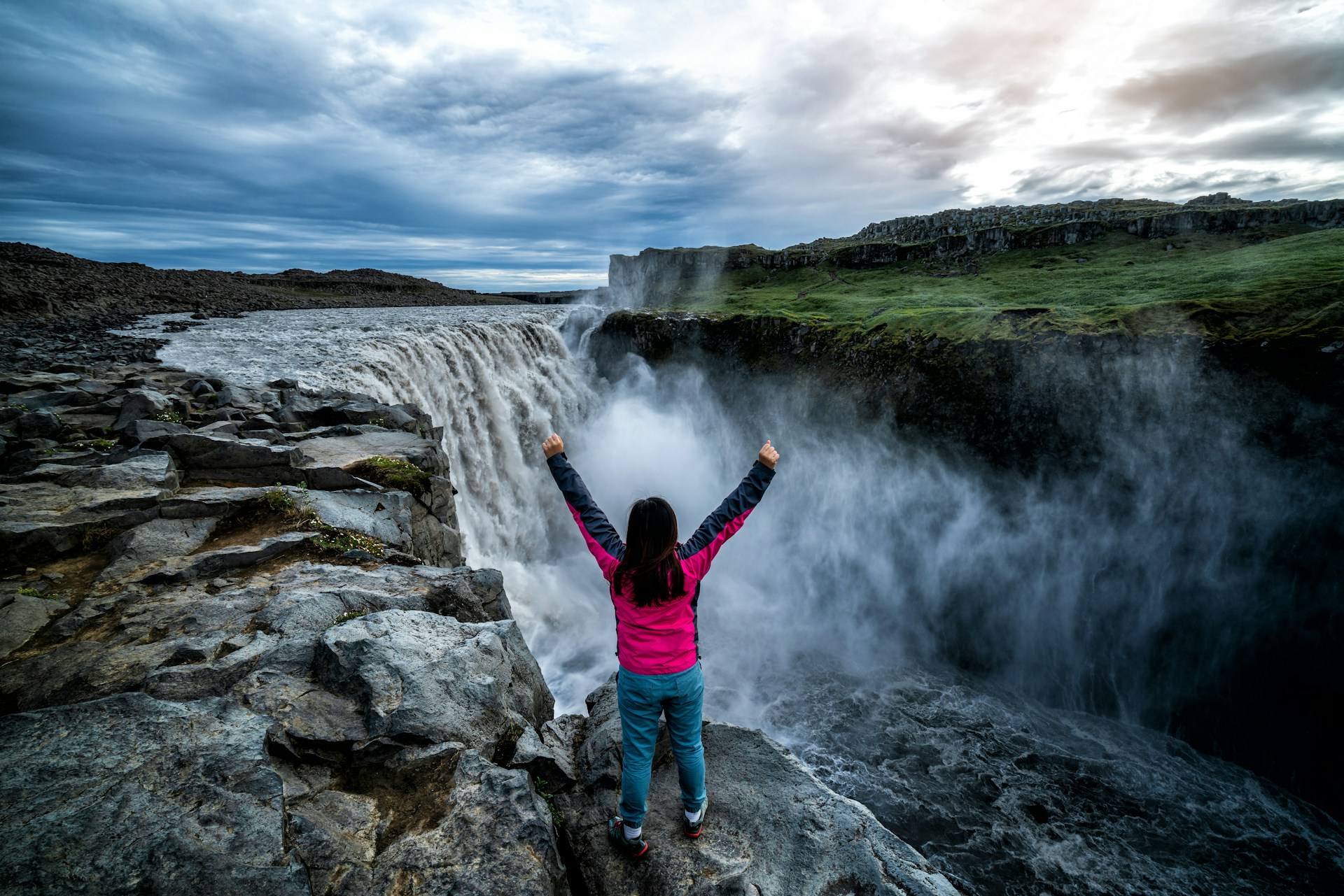 lady standing near selfoss waterfall